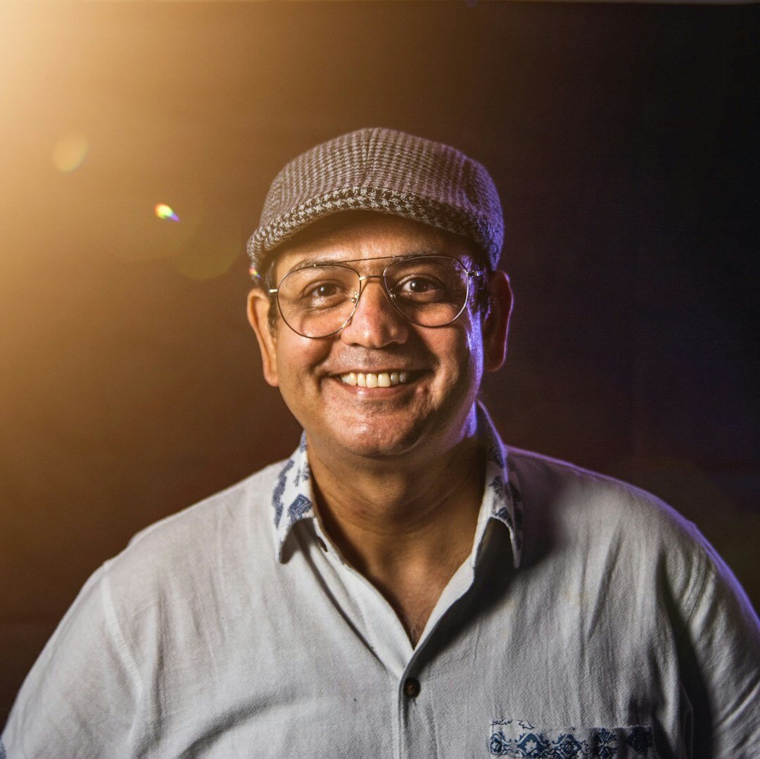 Studio portrait of a smiling senior man with glasses