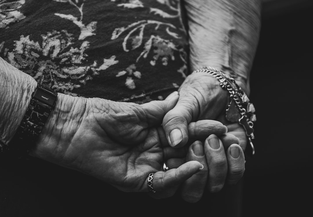 Caregiver holding hands with a senior person indoors