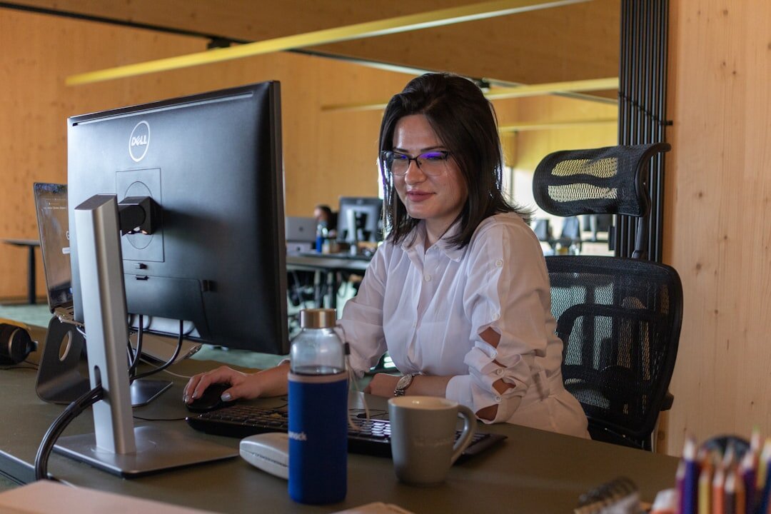 Friendly staff member smiling while talking on the phone at a desk